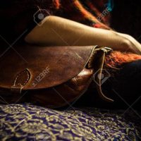 Woman with handbag sitting on old vintage sofa